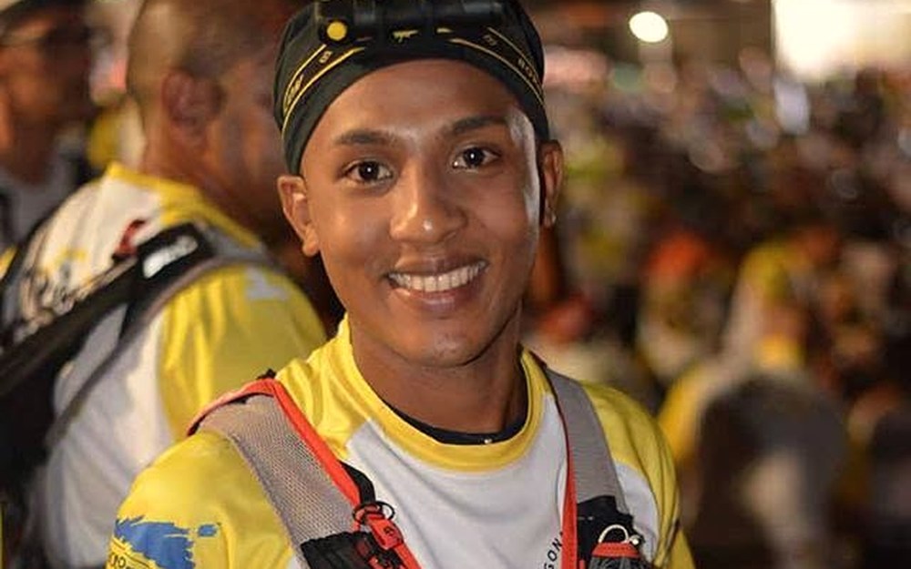 Christopher « BB » Camachetty à un ravitaillement de nuit de la Diagonale des Fous, lampe frontale et gilet d’hydratation